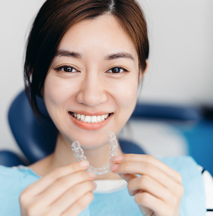 patient holding her invisalign in santa barbara